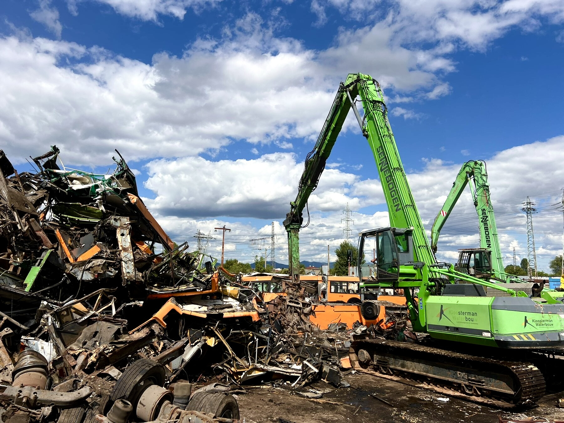 Площадката на Balkan Recycling Center в София: машини за претоварване на скрап до купчина разкомплектовани превозни средства