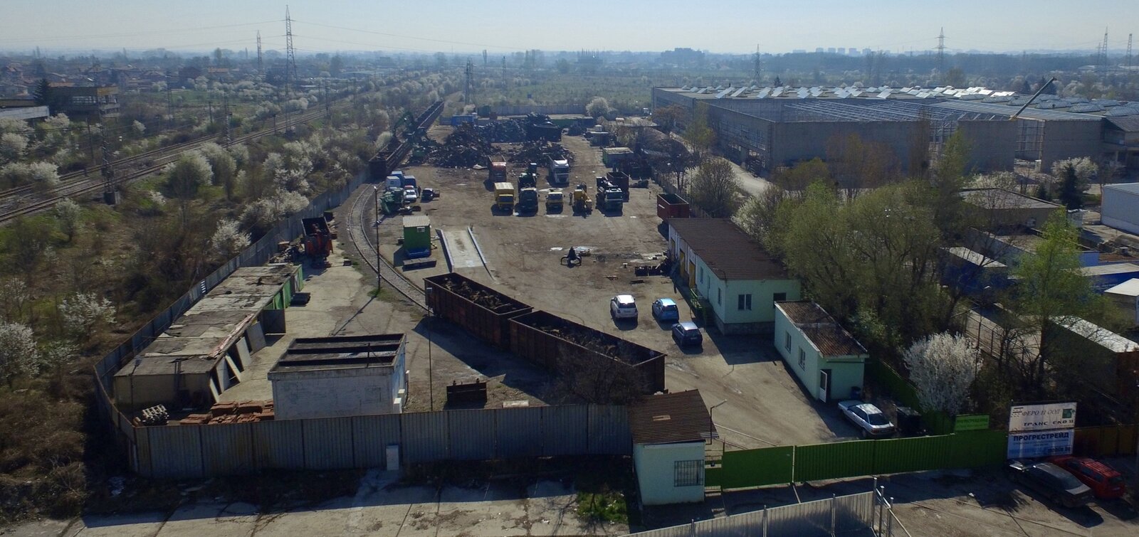 Площадката на Balkan Recycling Center в София, снимана отвисоко: железопътна линия, кантар, камиони и складови площи